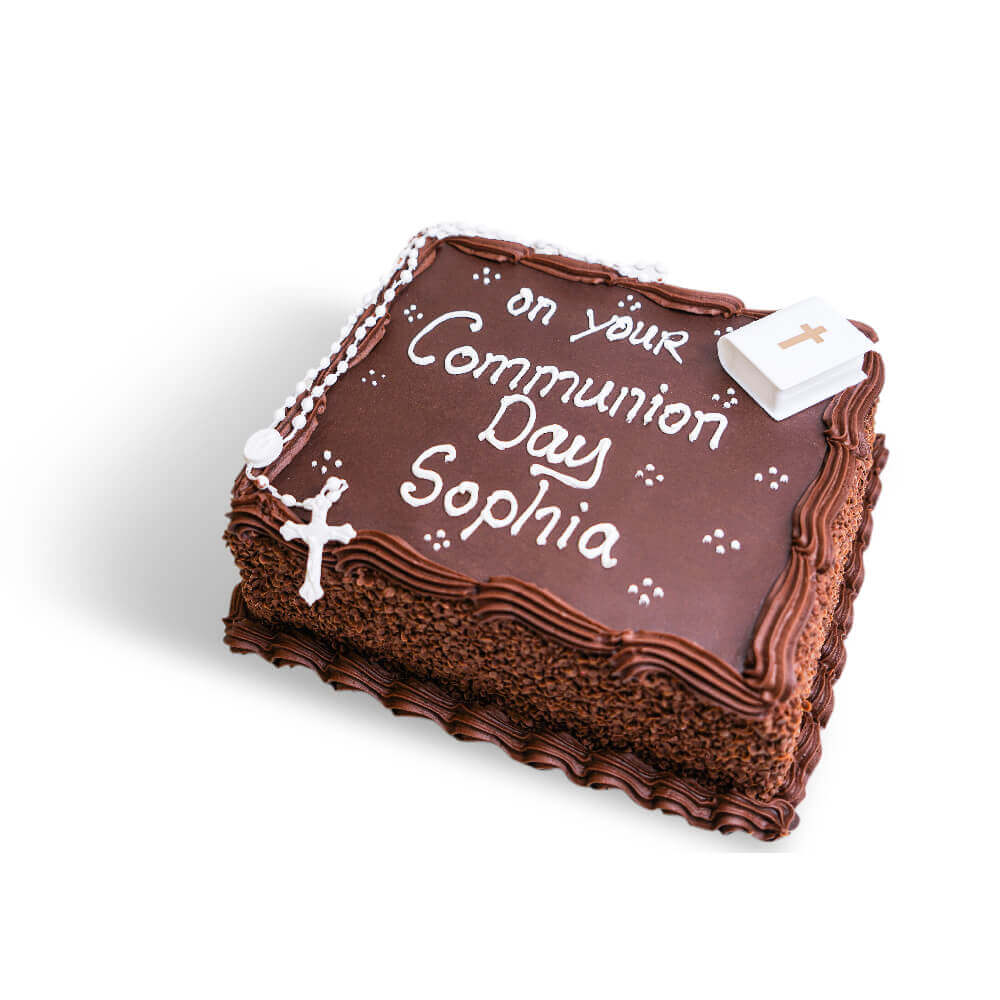A chocolate communion cake with white writing and decoration